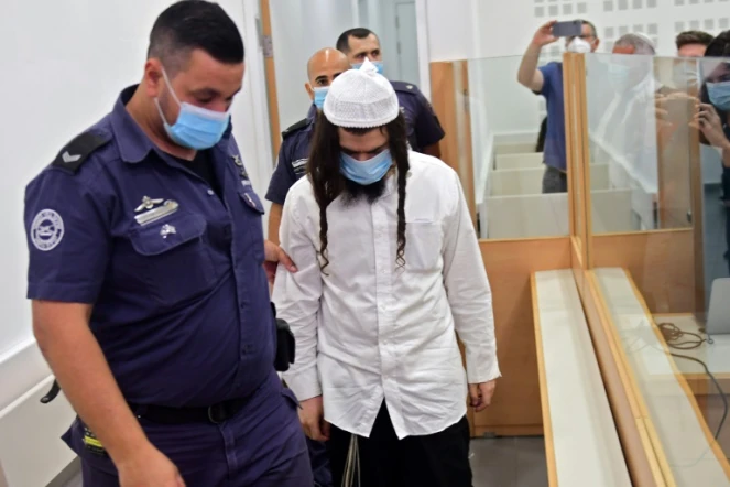 Amiram Ben-Ouliel, un colon israélien conduit par la police au tribunal de Lod, dans le centre d?Israël le 18 mai 2020, où il a été jugé pour triple meurtre d'une famille palestinienne