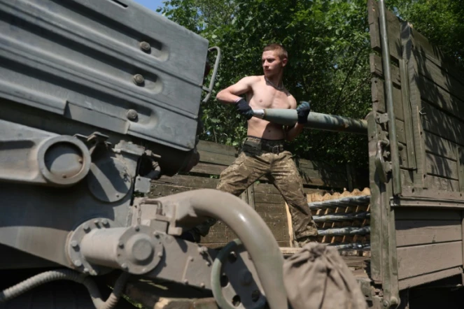 Un soldat ukrainien charge une batterie de roquettes près d'Izyum, au sud de Kharkiv, le 11 juin 2022 dans l'est de l'Ukraine
