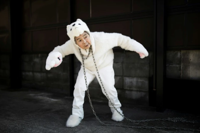 La Japonaise Kimiko Nishimoto vêtue d'un costume de chien pose pour un selfie devant sa maison, le 16 janvier 2018 à Kumamoto