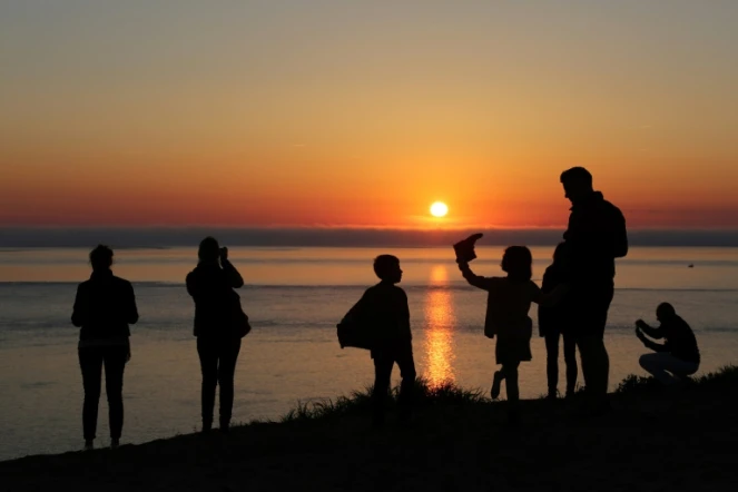 Une famille regarde le coucher du soleil au sommet de la dune du Pyla au Pyla-sur-Mer (Gironde), le 9 avril 2017 