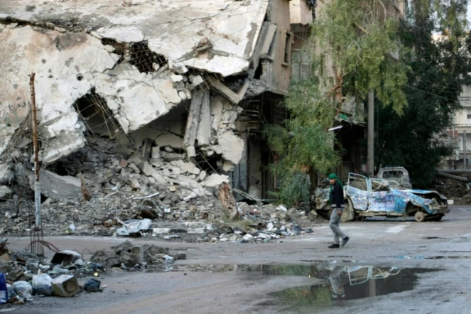 Un homme marche dans une rue détruite de la ville syrienne de Deir Ezzor, le 15 février  2014