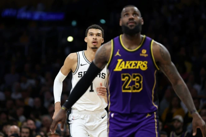 Le joueur français des San Antonio Spurs Victor Wembanyama (#1), avec devant lui la légende des LA Lakers LeBron James, lors d'un match de saison régulière de NBA, le 23 février 2024 à Los Angeles