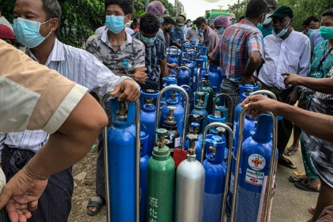 Des gens attendent pour remplir des bouteilles d'oxygène pour leurs proches atteints de Covid-19, à Rangoun le 14 juillet 2021