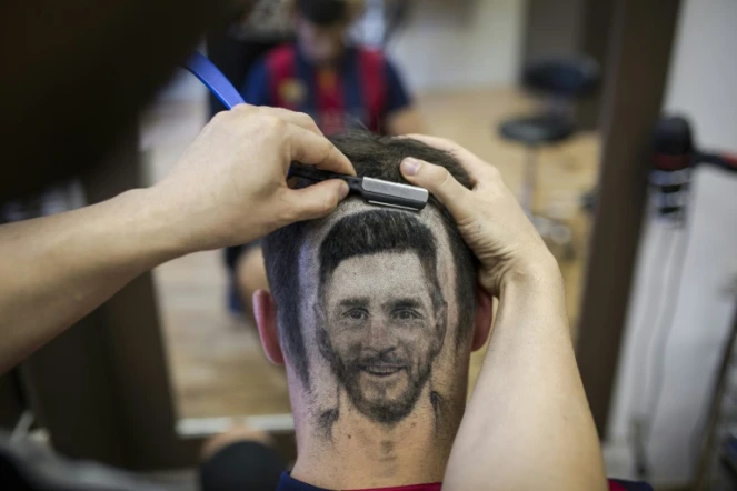 Le coiffeur serbe Mario Hvala dessine Messi sur l'arrière du crâne d'un client à Novi Sad, en Serbie, le 10 juin 2018 