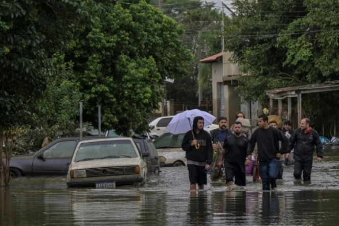 Des habitants se déplacent dans une rue inondée de la ville de Canoas, dans le sud du Brésil, le 13 mai 2024