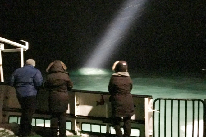 Des personnes à bord d'un bateau qui participaient aux recherches d'un hélicoptère disparu dans l'Arctique, le 26 octobre 2017 