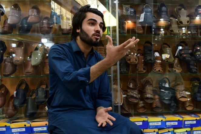 Shahzad Alam, réfugié afghan, lors d'un entretien avec l'AFP dans sa boutique de chaussures à Peshawar le 29 septembre 2018