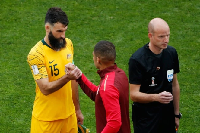 Le millieu de terrain australien Mile Jedinak (g) serre la main de l'attaquant péruvien Paolo Guerrero (c) à Sotchi le 26 juin 2018 lors du Mondial