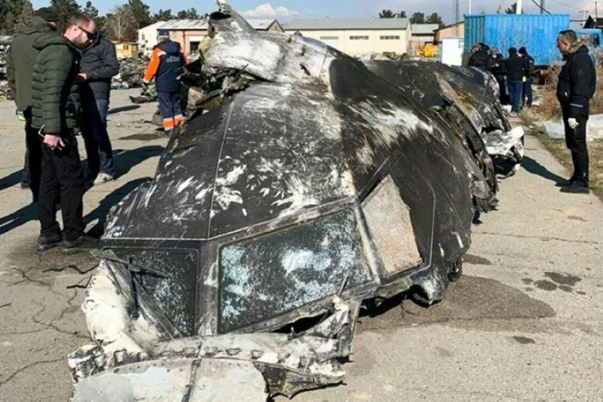 Une photo obtenue et diffusée le 11 janvier 2020 par le Conseil de la défense et de la sécurité nationales d'Ukraine, montre des experts autour des débris de l'avion ukrainien abattu "par erreur" par l'Iran après son décollage de Téhéran le 8 janvier 2020