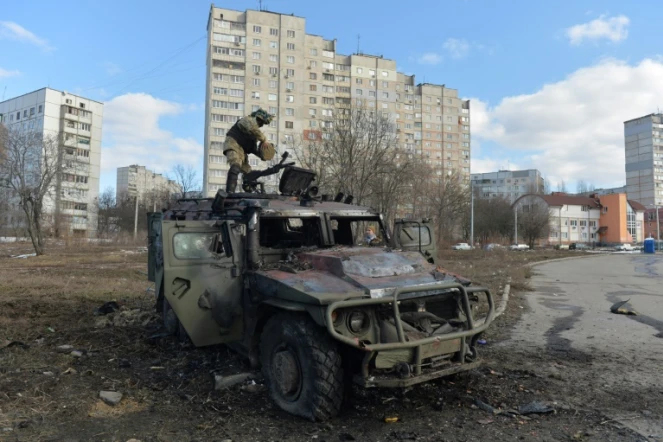 Un combattant ukrainien inspecte un véhicule militaire russe détruit après des combats à Kharkiv (Ukraine), le 27 février 2022