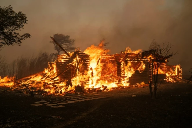 Une maison en feu lors d'incendies de forêt, le 11 août 2024 à Varnavas, au nord d'Athènes