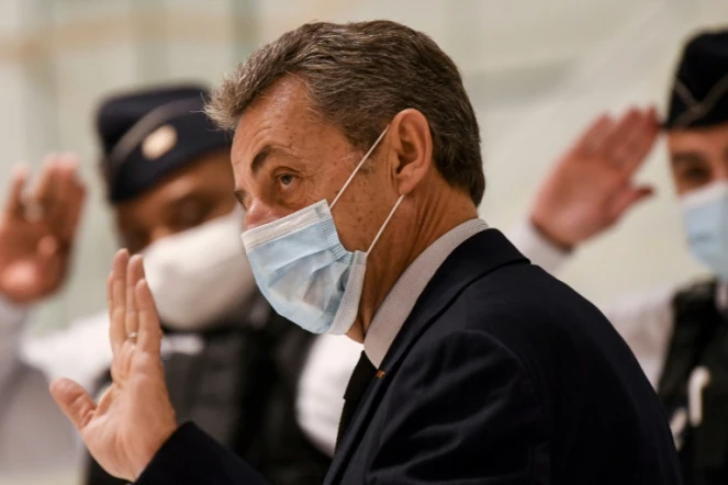 L'ancien président Nicolas Sarkozy salue d'un geste les policiers au dernier jour de son procès pour corruption le 10 décembre 2020 au Palais de justice de Paris 
