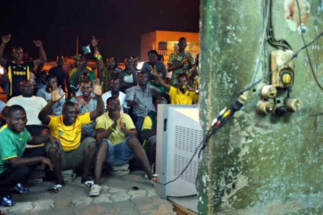 Des supporters togolais suivent sur une télévision en plein air le quart de finale de la CAN contre le Burkina Faso, le 3 février 2013 à Lomé