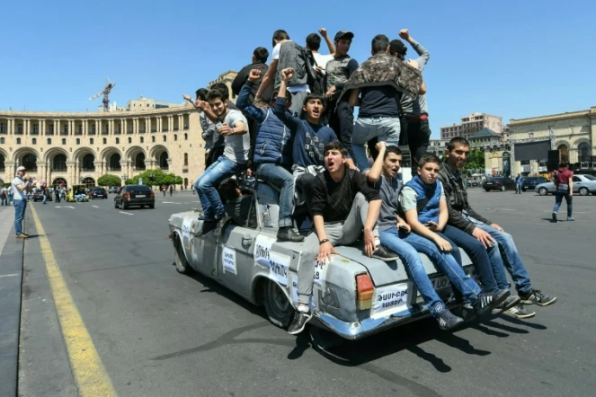 De jeunes Arméniens partisans de l'opposition défilent sur une voiture dans Erevan le jeudi 26 avril 2018