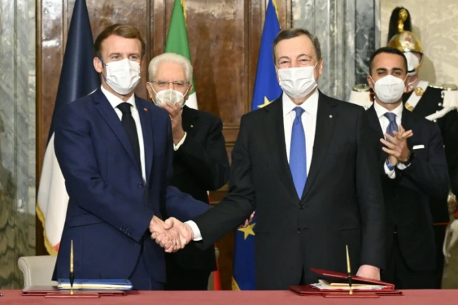 Au premier plan : Le président français Emmanuel Macron serre la main du Premier ministre italien Mario Draghi après la signature d'un traité bilatéral, le 26 novembre 2021 à Rome