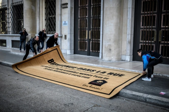 Des militants de la fondation Abbé Pierre déroulent devant le ministère du Logement à Paris un paillasson géant sur lequel est écrit "Bienvenue dans la rue", le 31 mars 2019