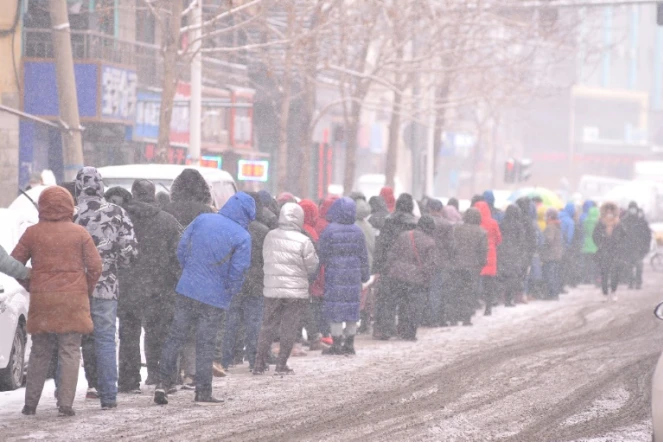 Des personnes font la queue sous la neige pour faire des tests Covid-19 à Harbin, dans la province du Heilongjiang, dans le nord-est de la Chine, le 2 mars 2022