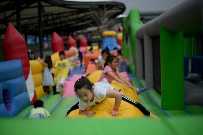 Des enfants jouent dans un château gonflable dans un centre commercial de Pékin, le 1er juin 2021 en Chine