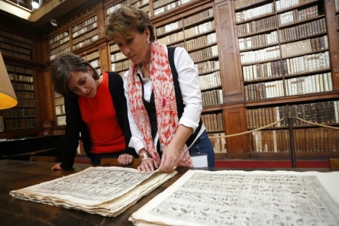 Elisabeth Perié, responsable des bibliothèques d'Ajaccio, et Vannina Schirinsky-Schikhmatoff, conservatrice, admirent le "Thesaurum Hyeroglyphicorum", premier livre d'égyptologie, dans la bibliothèque d'Ajaccio, le 18 avril 2018