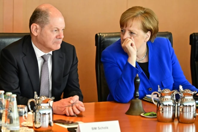 Le ministre allemand des Finances Olaf Scholz (G) au côté de la chancelière Angela Merkel (D) à Berlin le 10 avril 2019