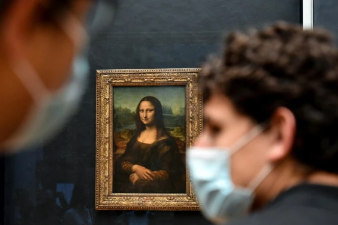Un visiteur portant un masque devant le tableau de La Joconde, au Louvre, le 19 mai 2021 à Paris