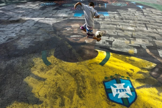 Un enfant joue au football dans une rue de la favela de Sao Paulo ou a grandi le N.9 de la Seleçao Gabriel Jesus, le 22 juin 2018