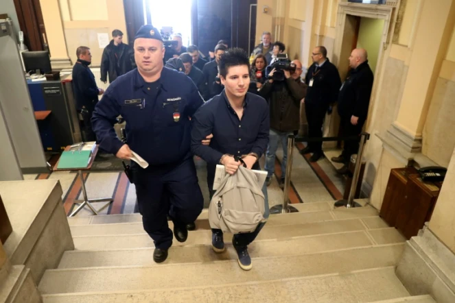 Le hacker Rui Pinto (d) est escorté par un officier de police judiciaire à son arrivée à la Cour de Budapest, en Hongrie, le 5 mars 2019