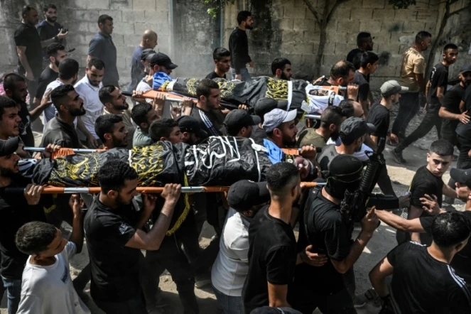 Des Palestiniens portent les corps de Palestiniens tués lors d'un raid israélien dans le nord de la Cisjordanie occupée, lors de leurs funérailles dans le camp de réfugiés de Jénine, le 6 septembre 2024