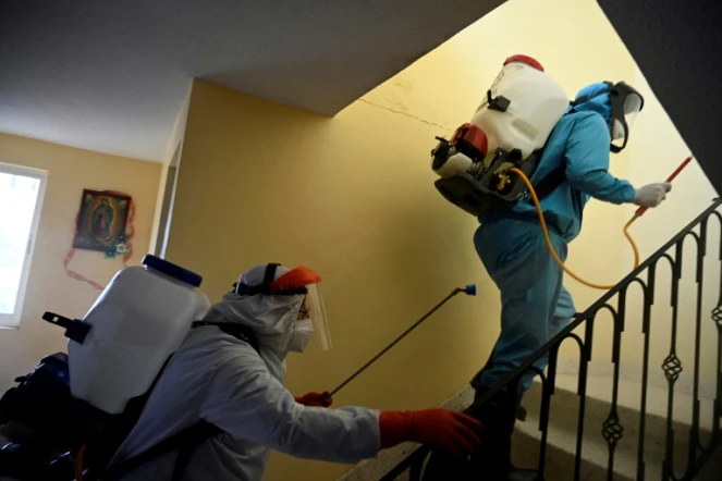 Par précaution contre le virus Covid-19, du personnel municipal désinfecte une habitation dans le quartier de Xochimilco à Mexico, le 26 août