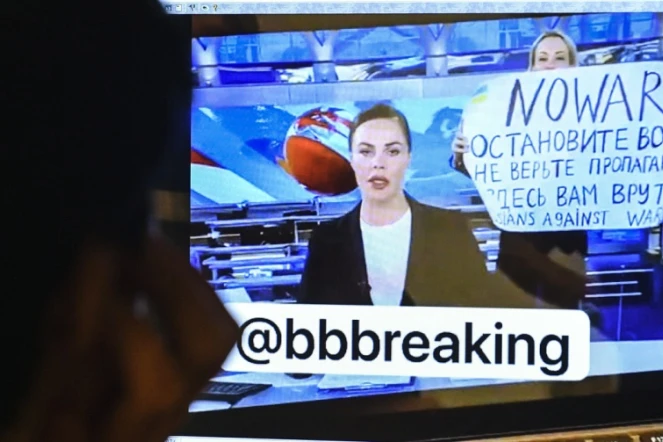 Une femme apparaît derrière une présentatrice pendant le journal télévisé de la plus importante chaîne de Russie avec une pancarte sur laquelle est écrit "Non à la guerre. Ne croyez pas la propagande. On vous ment, ici", le 14 mars 2022