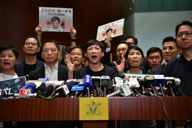Une parlementaire pro-démocratie de Hong Kong, Tanya Chan (C), s'adresse aux médias après l'interruption du discours de politique générale de la cheffe de l'exécutif Carrie Lam, caricaturée les mains ensanglantées sur des affiches, le 16 octobre 2019