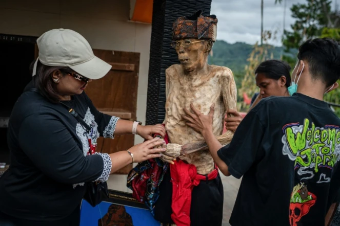 Des membres d'une famille toraja habillent le corps exhumé d'un proche pendant le rituel traditionnel "Manene" à Pangala, dans le sud de l'île des Célèbes, le 27 août 2024s en Indonésie