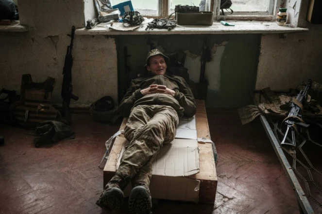 Un soldat ukrainien se repose sur un lit de fortune dans un bâtiment abandonné après avoir combattu sur la ligne de front pendant deux mois près de Kramatorsk, dans l'est de l'Ukraine, le 30 avril 2022