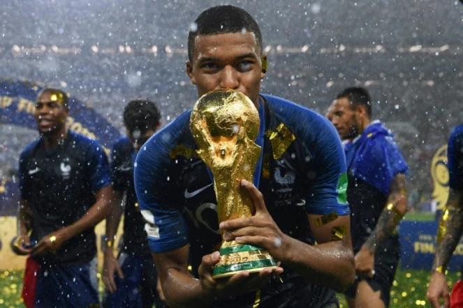L'attaquant français Kylian Mbappé embrasse la Coupe du monde, remportée à seulement 19 ans avec les Bleus, le 15 juillet 2018 à Moscou