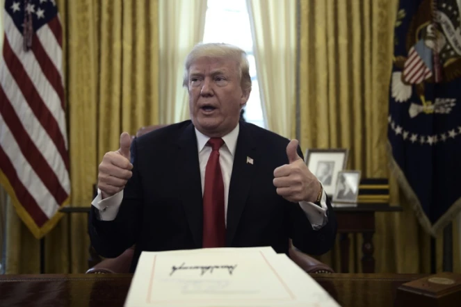 Le président américain Donald Trump promulgue la baisse d'impôts dans le bureau ovale de la Maison Blanche à Washington, le 22 décembre 2017 