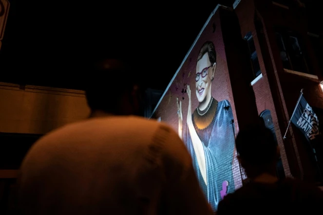 Des Américains rendent hommage à Ruth Bader Ginsburg devant une fresque murale la représentant à Washington