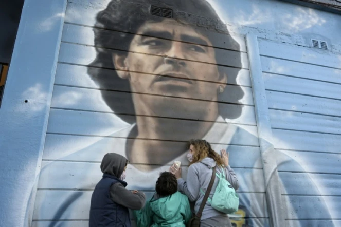Des personnes se recueillent devant une fresque murale de Diego Maradona, peinte par l'artiste Marley, le 22 juin 2021 à Buenos Aires