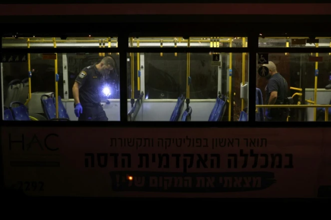Les forces de sécurité israéliennes inspectent un bus après une attaque armée dans le centre de Jérusalem le 14 août 2022