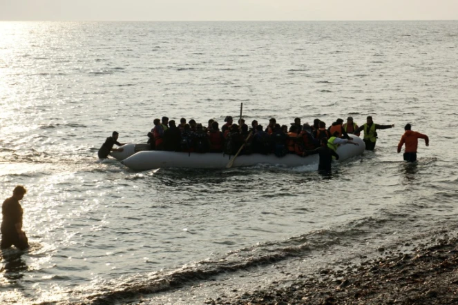 Des migrants sur un canot pneumatique débarquent sur l'île de Lesbos, le 20 mars 2016