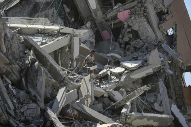 Un Palestinien tente de récupérer quelques affaires au milieu des décombres dans un secteur de Deir al Balah dont l'armée israélienne s'est retirée, le 29 août 2024