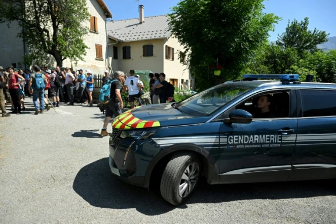 Un véhicule de la gendarmerie passe près de bénévoles participant aux recherches d'Emile, deux ans et demi, disparu samedi dernier, le 10 juillet 2023 au Vernet, dans les Alpes-de-Haute-Provence