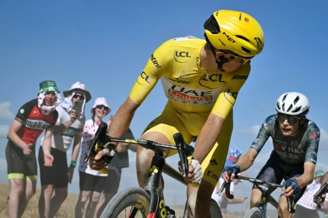 Le Slovène de l'équipe UAE Tadej Pogacar, porteur du maillot jaune, regarde derrière lui le Danois de la formation Visma Jonas Vingegaard, son principal rival dans le Tour de France, lors de la 9e étape autour de Troyes en France, le 7 juillet 2024