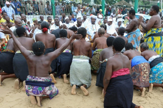 Des adeptes du vaudou s'agenouillent devant les prêtres lors d'une cérémonie de purification qui a lieu au milieu de la place publique de Bè, un quartier populaire de Lomé, le 7 juillet 2017