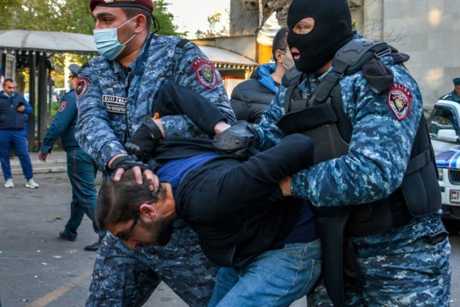 Des policiers arméniens arrêtent un manifestant lors d'un rassemblement contre l'accord avec l'Azerbaïdjan dans le conflit au Nagorny Karabakh, le 12 novembre 2020 à Erevan
