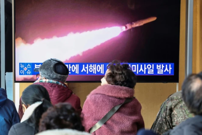 Des gens regardent un journal télévisé diffusant des images d'archives d'un essai de missile nord-coréen, dans une gare de Séoul, le 30 janvier 2024
