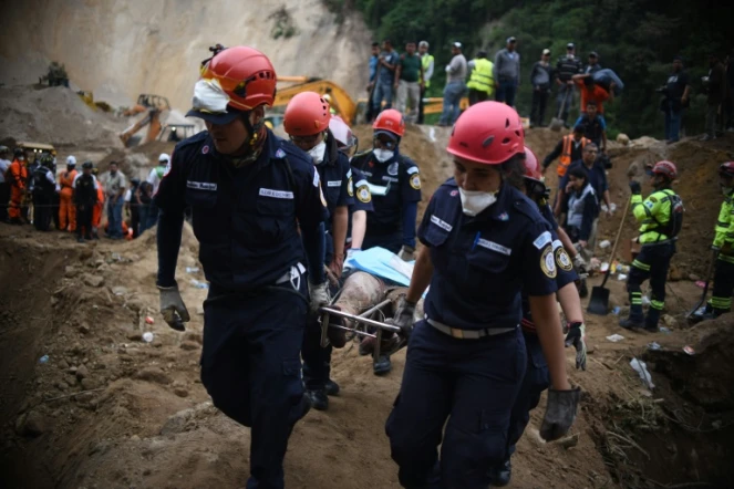 Des pompiers transportent un corps après un glissement de terrin près de Guatemala city le 3 octobre 2015