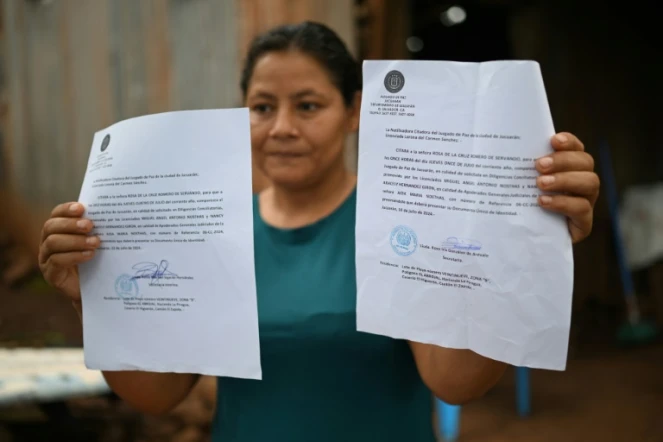 Rosa Romero montre deux assignations du tribunal de Jucuaran pour libérer la parcelle où elle vit sur la plage d'El Higueron, le 20 juillet 2024 au Salvador