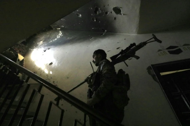 Un membre des Forces démocratiques syriennes (FDS) patrouille à l'intérieur d'un immeuble près de la Vieille ville de Raqa, le 3 septembre 2017