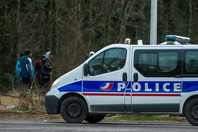 Des migrants et une voiture de police à Calais, le 3 mars 2017