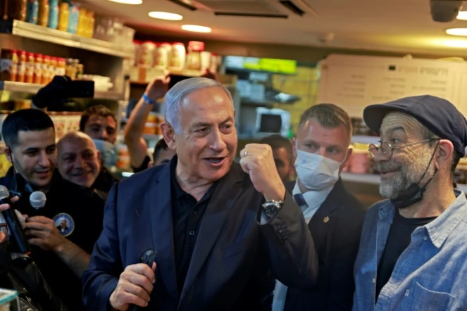 Le Premier ministre israélien Benjamin Netanyahu (Centre), s?adresse à ses partisans du Likoud sur le marché Mahane Yehuda à Jérusalem le 22 mars 2021, à la veille de la quatrième élection législative en deux ans